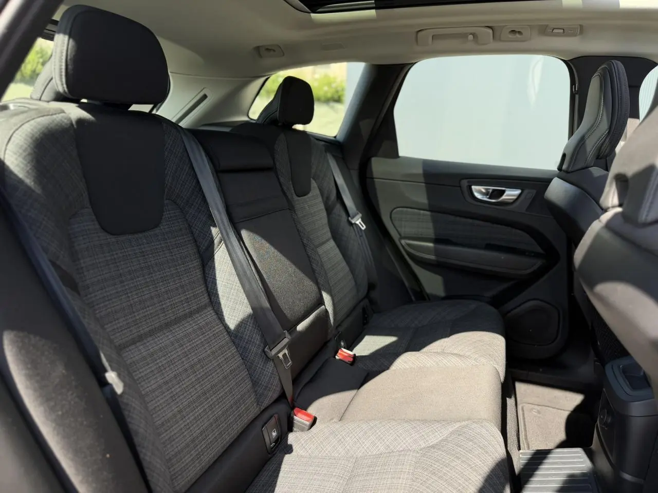 Vue latérale intérieure des sièges arrière gris à motifs du Volvo XC60 T6 AWD PHEV 350 Plus Style Chrome 2024.