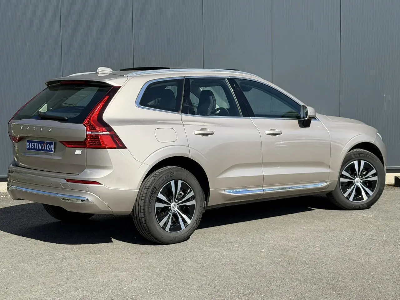 Vue 3/4 arrière droite du Volvo XC60 T6 AWD PHEV 2024 en gris Dusk avec jantes alliage et contours chromés.