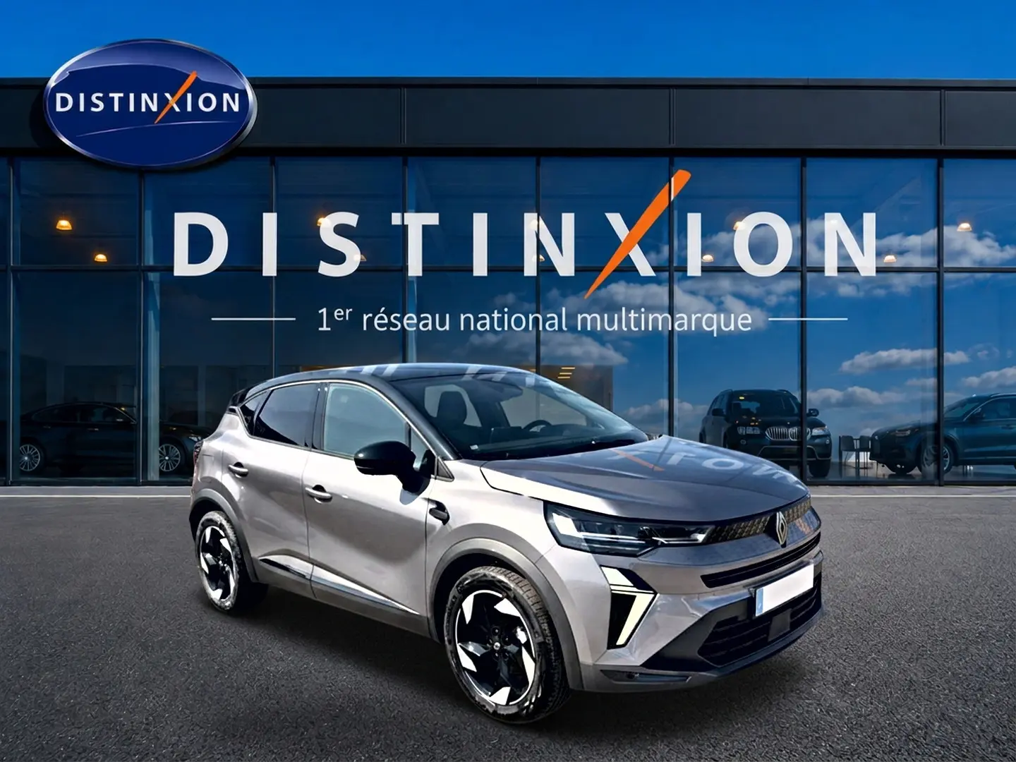 Renault Captur 1.2 TCe 115 Techno gris Cassiope toit noir, vue 3/4 avant avec jantes noires et blanches, devant showroom Distinxion.