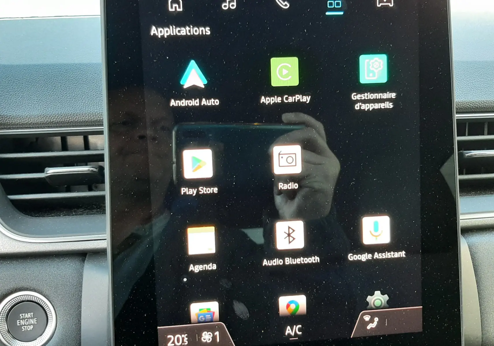 Écran tactile central du Renault Captur 2024 affichant les applications Android Auto, Apple CarPlay et radio, avec bouton start engine stop visible.