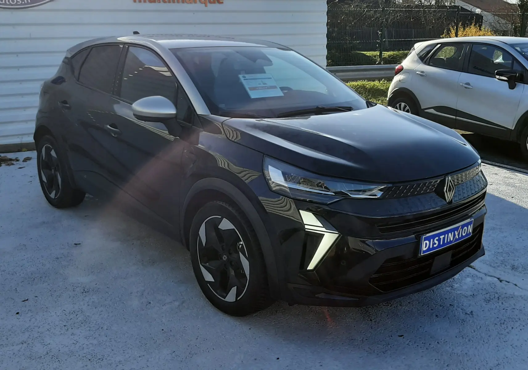 Renault Captur 2024 noir métal avec toit gris, vue 3/4 avant droit mettant en valeur ses phares LED et jantes biton.
