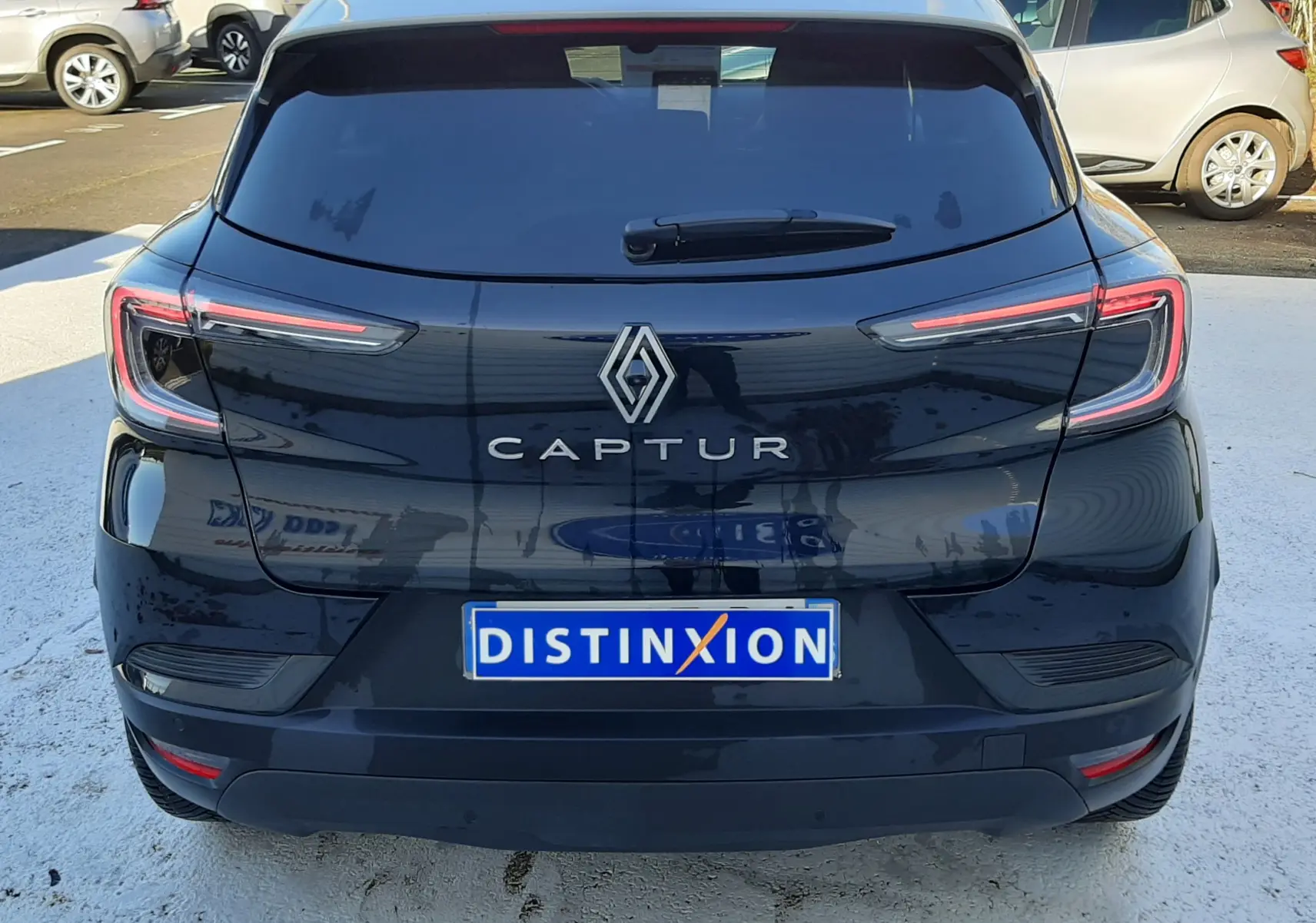 Vue arrière d'un Renault Captur noir métal avec toit gris, mettant en valeur ses feux LED et le logo central.