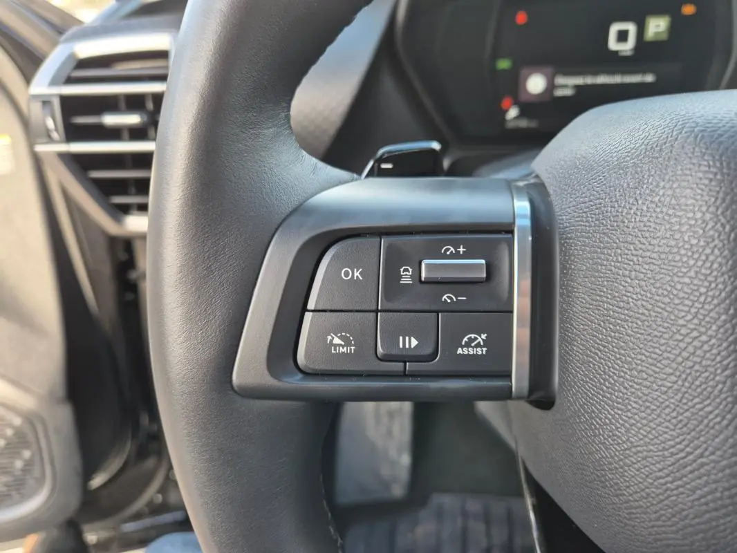 Gros plan sur les commandes du volant cuir du Citroën C5 X noir 2024, avec régulateur et assistant de conduite.