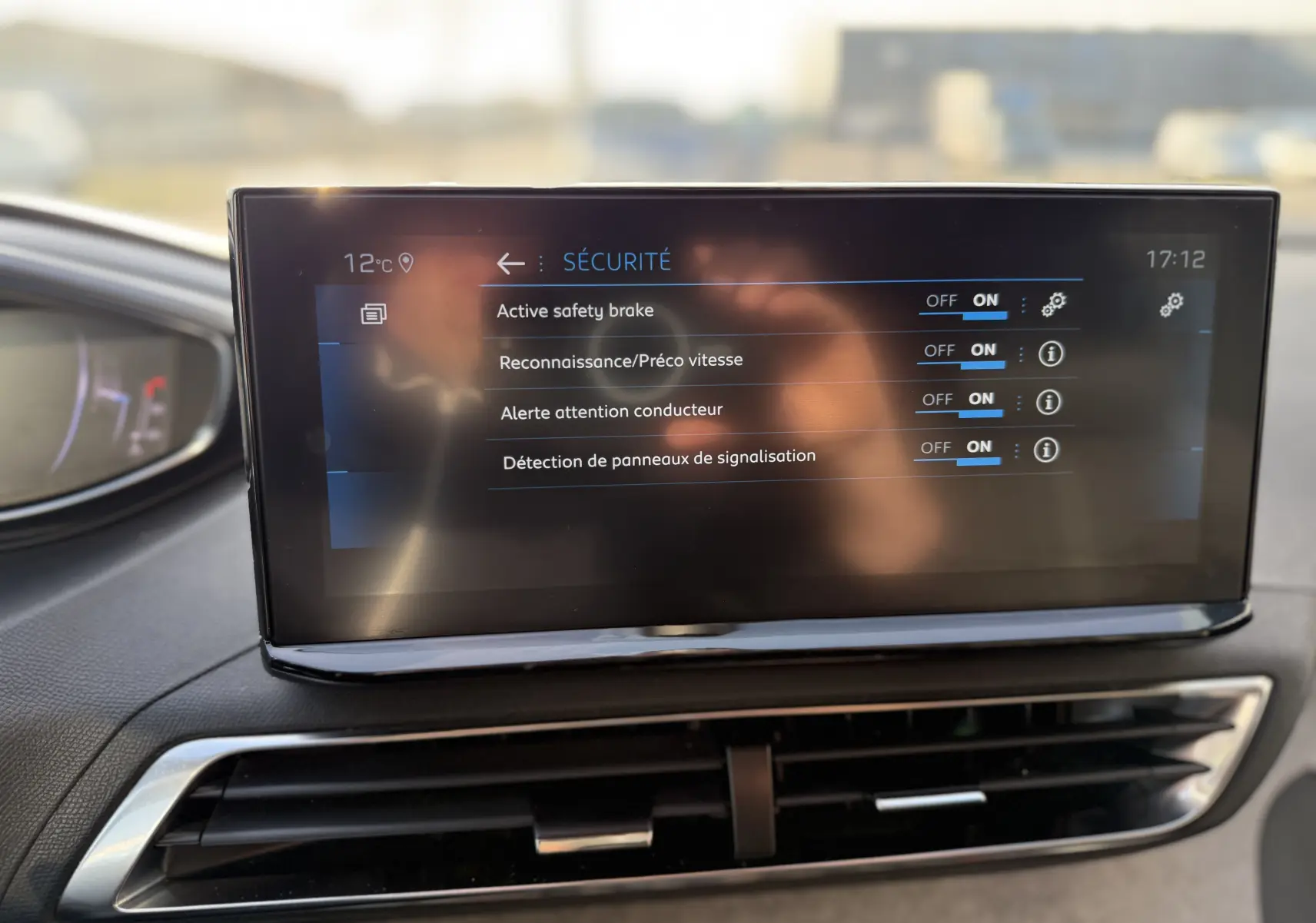 Écran tactile intérieur du Peugeot 3008 2022 montrant les options de sécurité activées, avec tableau de bord partiel visible.