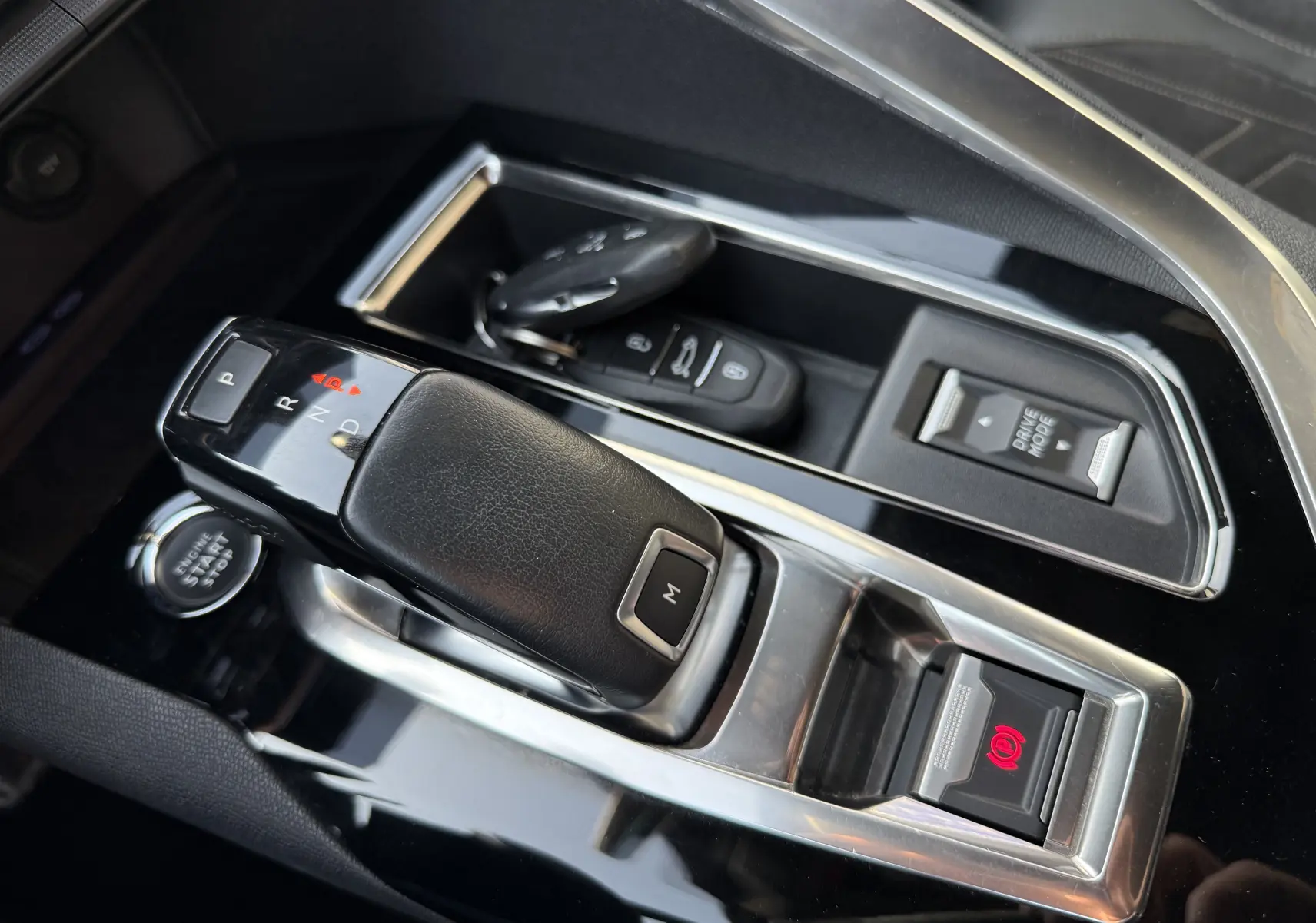 Gros plan sur la console centrale du Peugeot 3008 gris, montrant le levier de vitesses automatique et les commandes électroniques.