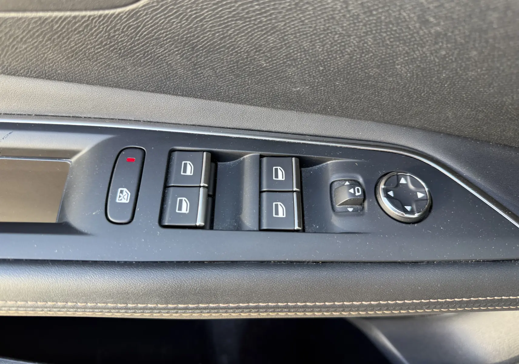 Vue rapprochée des commandes de lève-vitres et réglage des rétroviseurs sur la porte côté gauche d’un Peugeot 3008 gris.