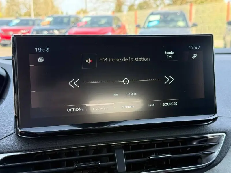Écran tactile central du Peugeot 3008 2024 affichant la radio FM, intérieur avec tableau de bord noir.