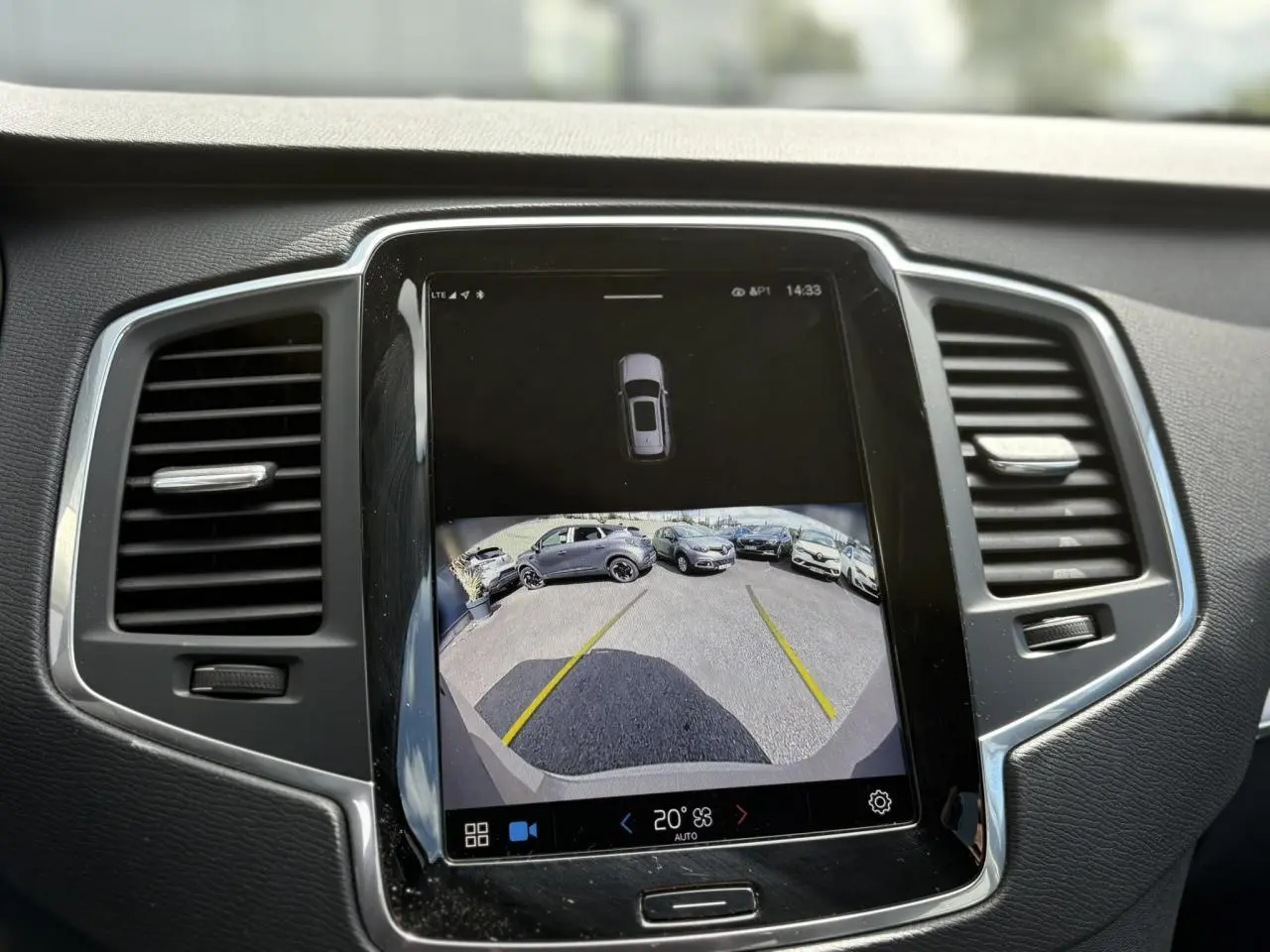Écran central tactile montrant la caméra de recul du Volvo XC90 T8 gris Dusk, entouré de la console noire et grise.