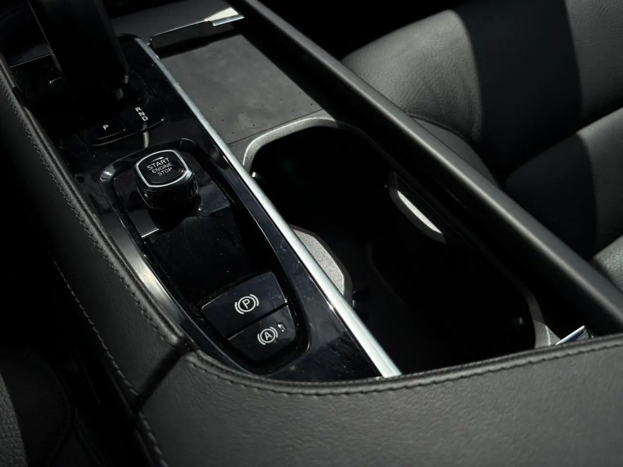 Gros plan sur la console centrale noire avec bouton Start/Stop et frein de parking du Volvo XC90 T8 gris Dusk.