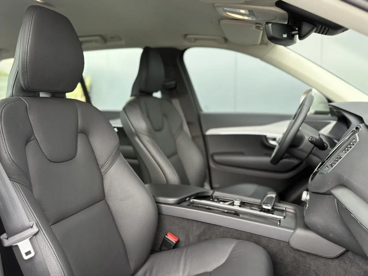 Vue intérieure côté droit du Volvo XC90 T8 AWD 2024, sièges cuir noir et console centrale épurée.