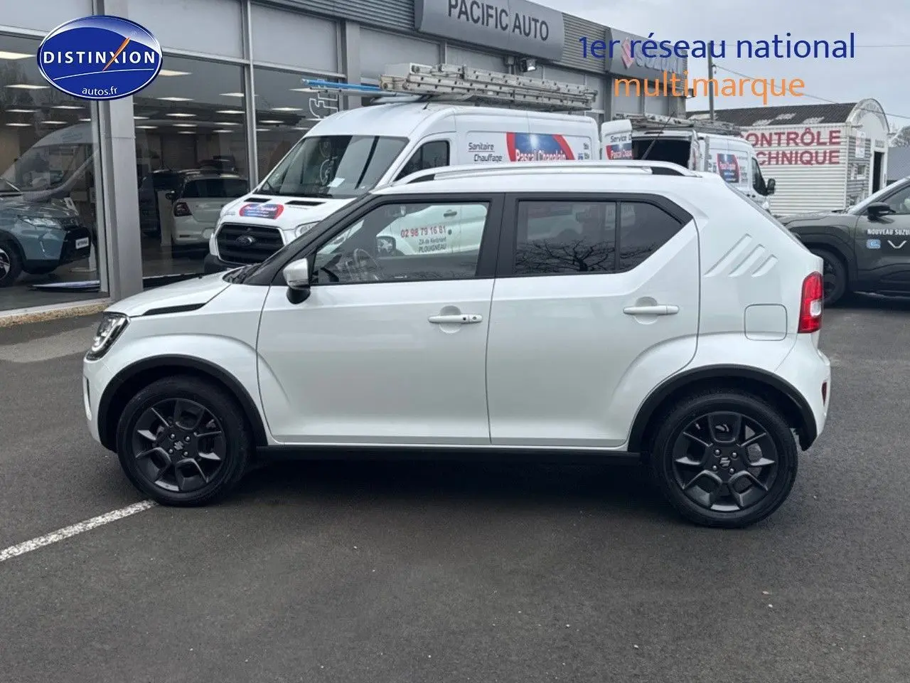 Profil côté gauche d'une Suzuki Ignis 2023 blanche nacrée avec jantes noires et vitres arrière surteintées.