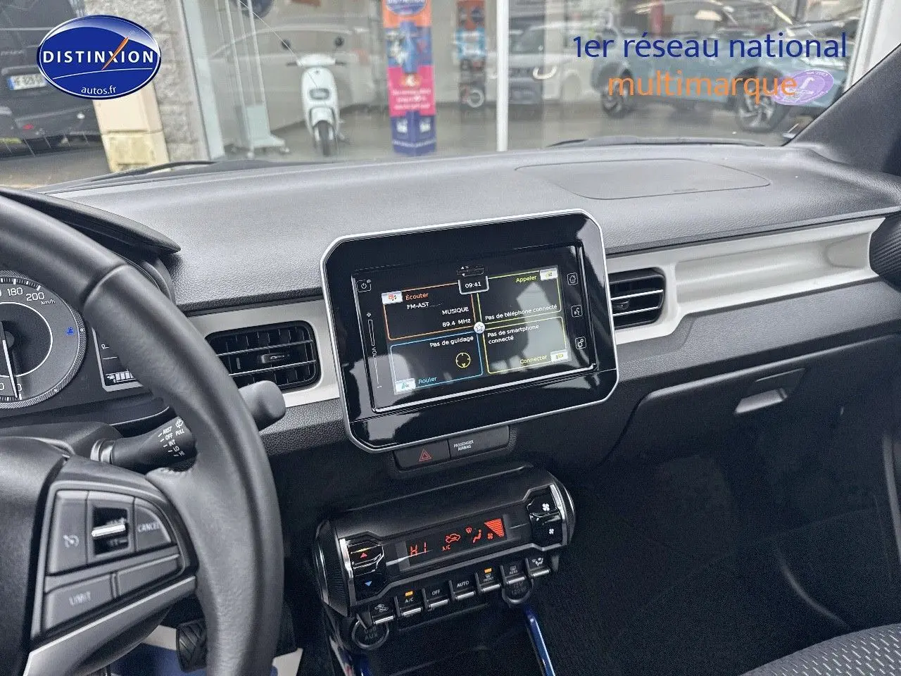 Vue intérieure du tableau de bord de la Suzuki Ignis 2023, écran tactile central et volant multifonction noir.