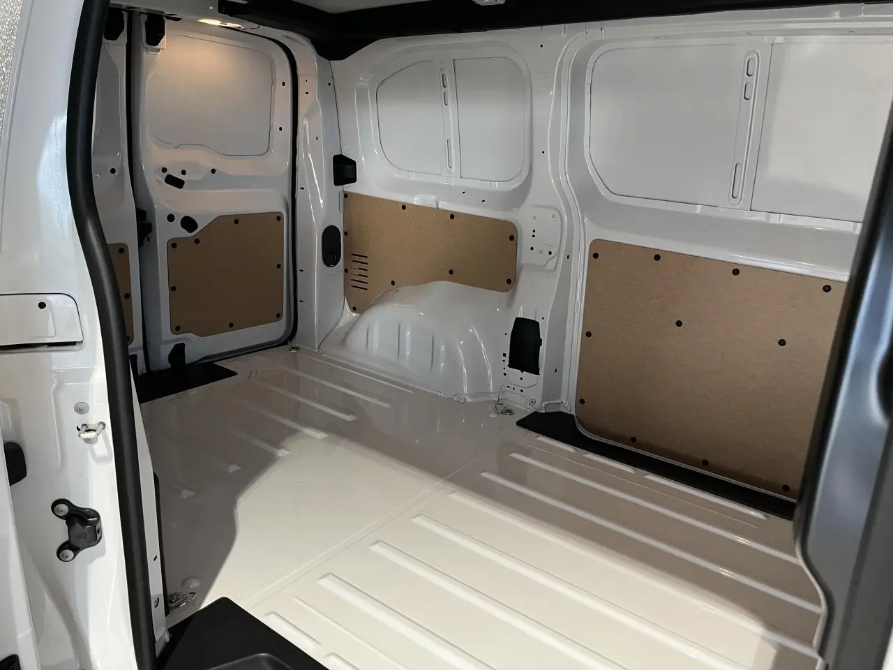 Intérieur de la zone de chargement du Peugeot Expert Fourgon blanc 2024, vue de profil avec panneaux de protection en bois.
