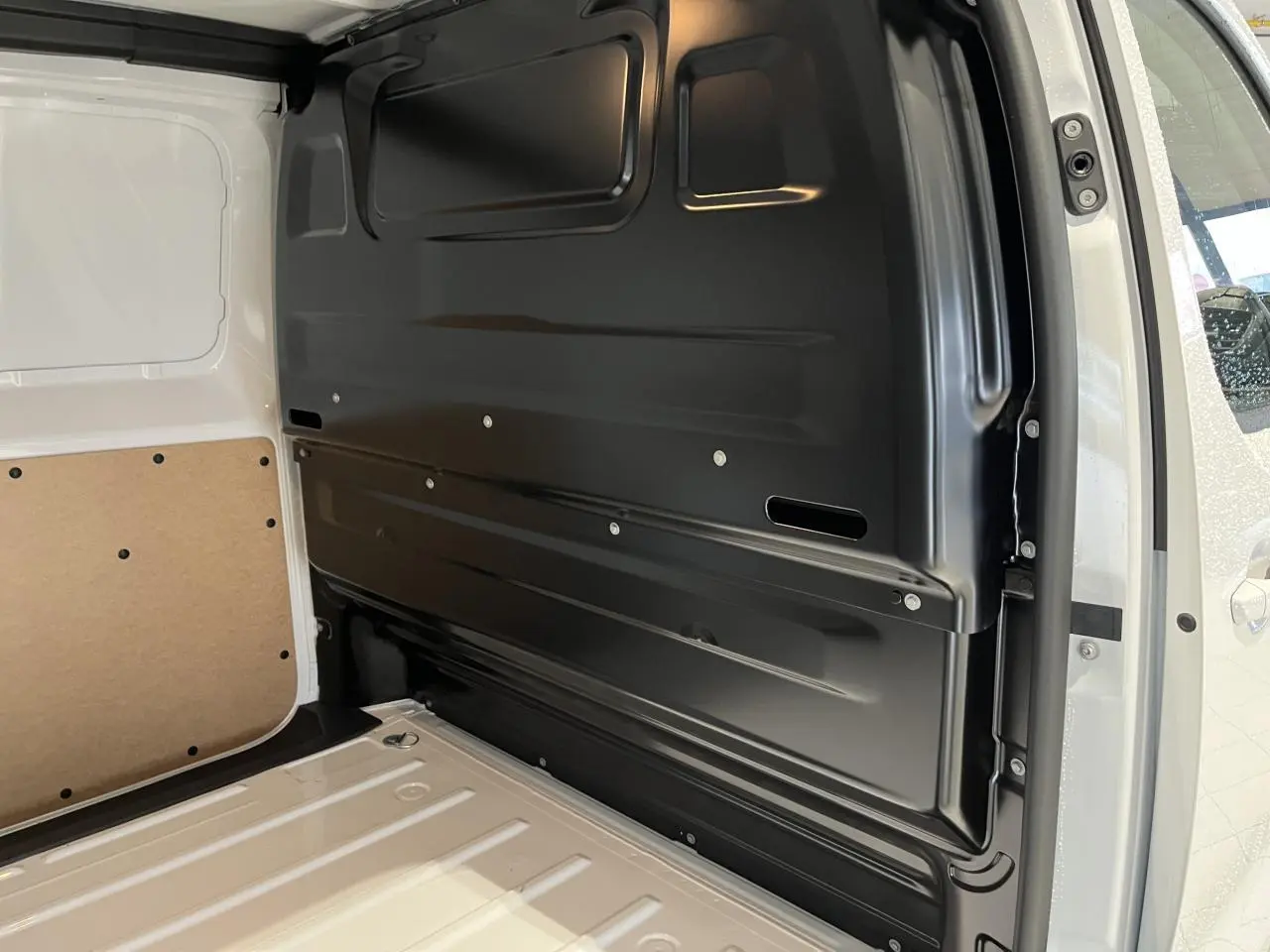 Vue intérieure de l’espace de chargement du Peugeot Expert Fourgon blanc 2024, montrant la cloison noire et le plancher métallique.