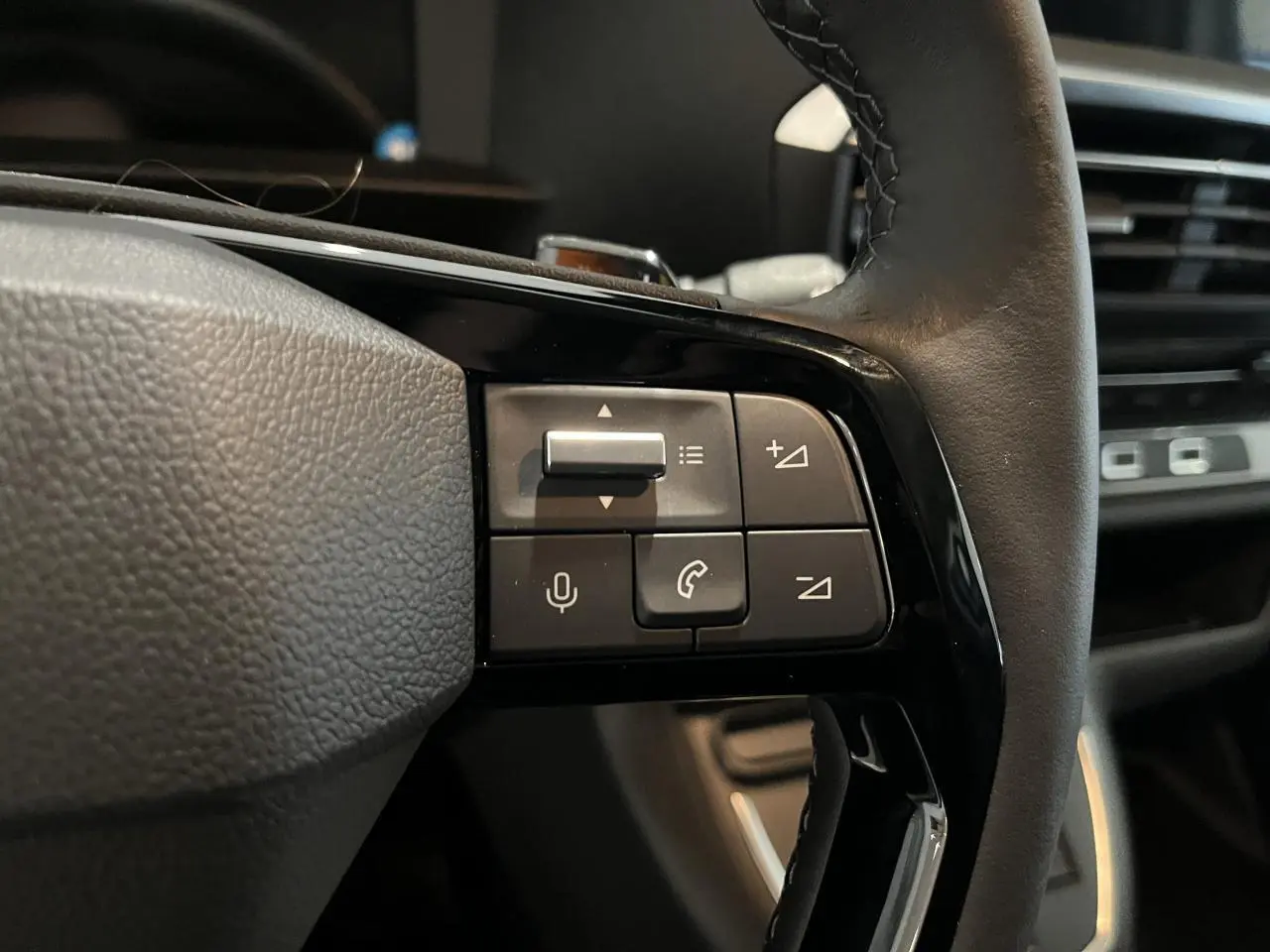 Gros plan sur les commandes au volant en cuir noir du Peugeot Expert Fourgon blanc, mettant en valeur les boutons multifonctions.