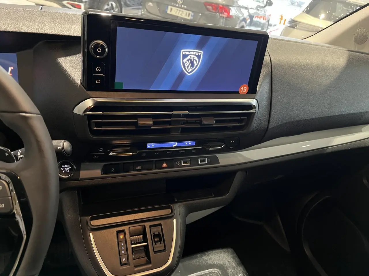 Vue intérieure rapprochée du tableau de bord du Peugeot Expert Fourgon blanc 2024 avec écran tactile 10 pouces et volant cuir.