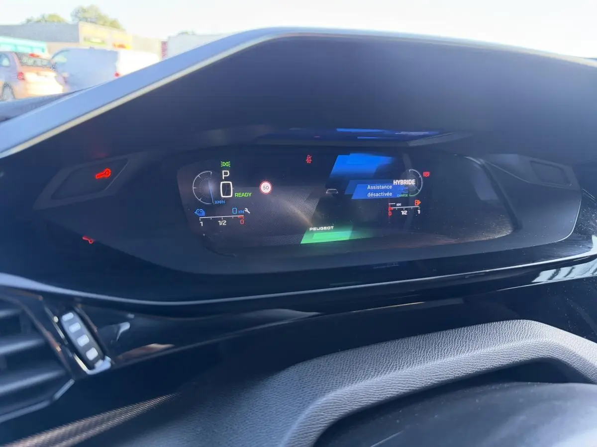 Vue rapprochée du combiné numérique Peugeot 308 2024 affichant les informations de conduite en mode hybride.