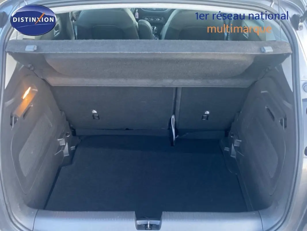 Coffre ouvert vu de l'arrière d'un Opel Crossland gris foncé 2022, montrant l'espace de chargement et la tablette cache-bagages.