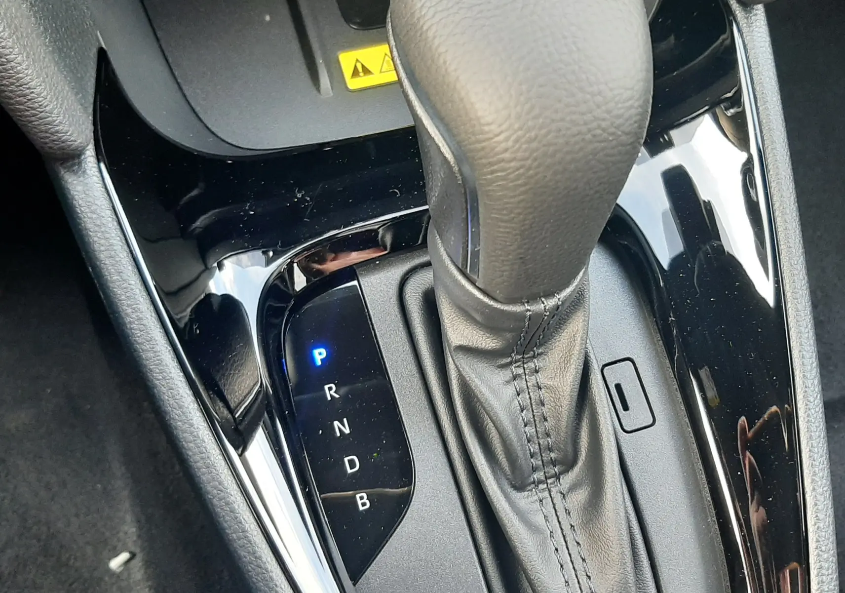Le levier de vitesses automatique en cuir noir de la Toyota Yaris Cross 130H Design 2025, vue rapprochée intérieure.