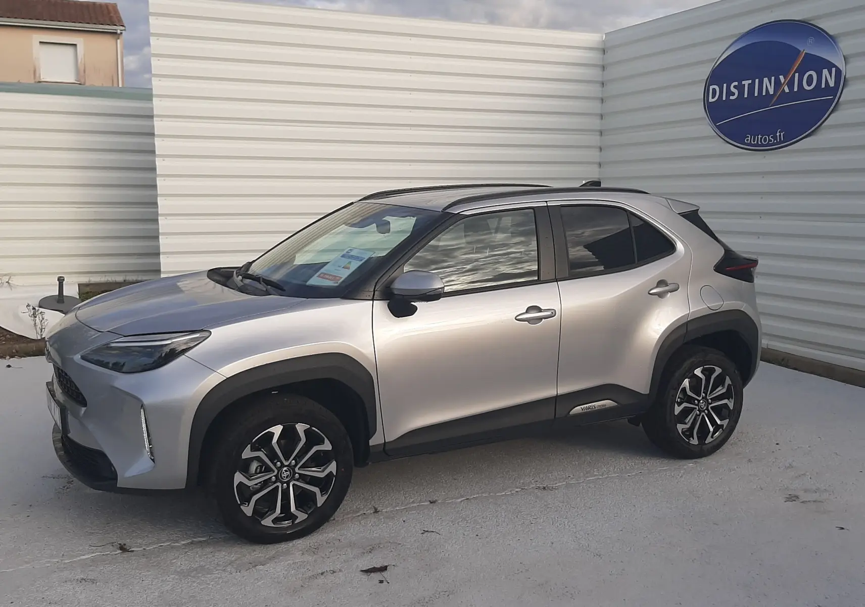 Toyota Yaris Cross 130H Design gris minéral vue 3/4 avant droit avec jantes alliage et toit noir.