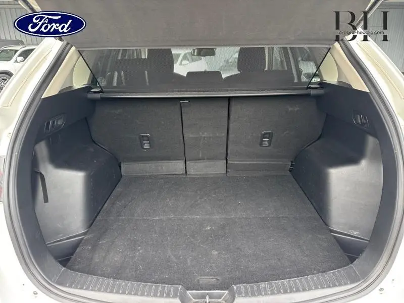 Coffre ouvert vu de l'arrière d'un Mazda CX-5 blanc nacré 2016, montrant un espace de chargement propre et spacieux.