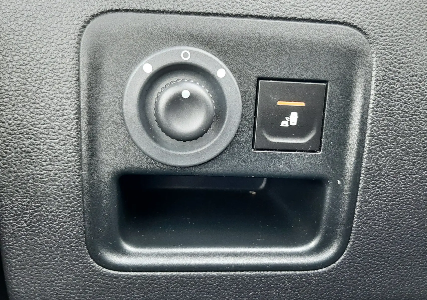 Gros plan sur les commandes de réglage des rétroviseurs intérieurs noirs du Dacia Duster gris Cassiopée, version 2019.