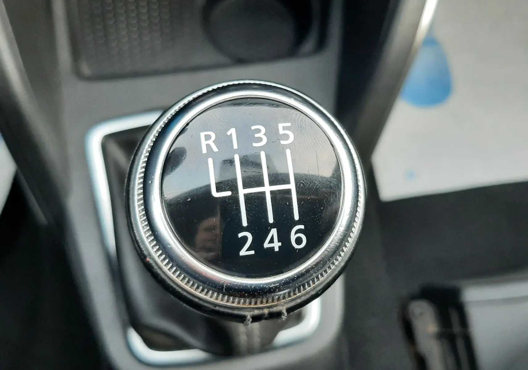 Gros plan sur le levier de vitesses manuel noir du Dacia Duster 1.5 Blue dCi, entouré de garnitures grises.