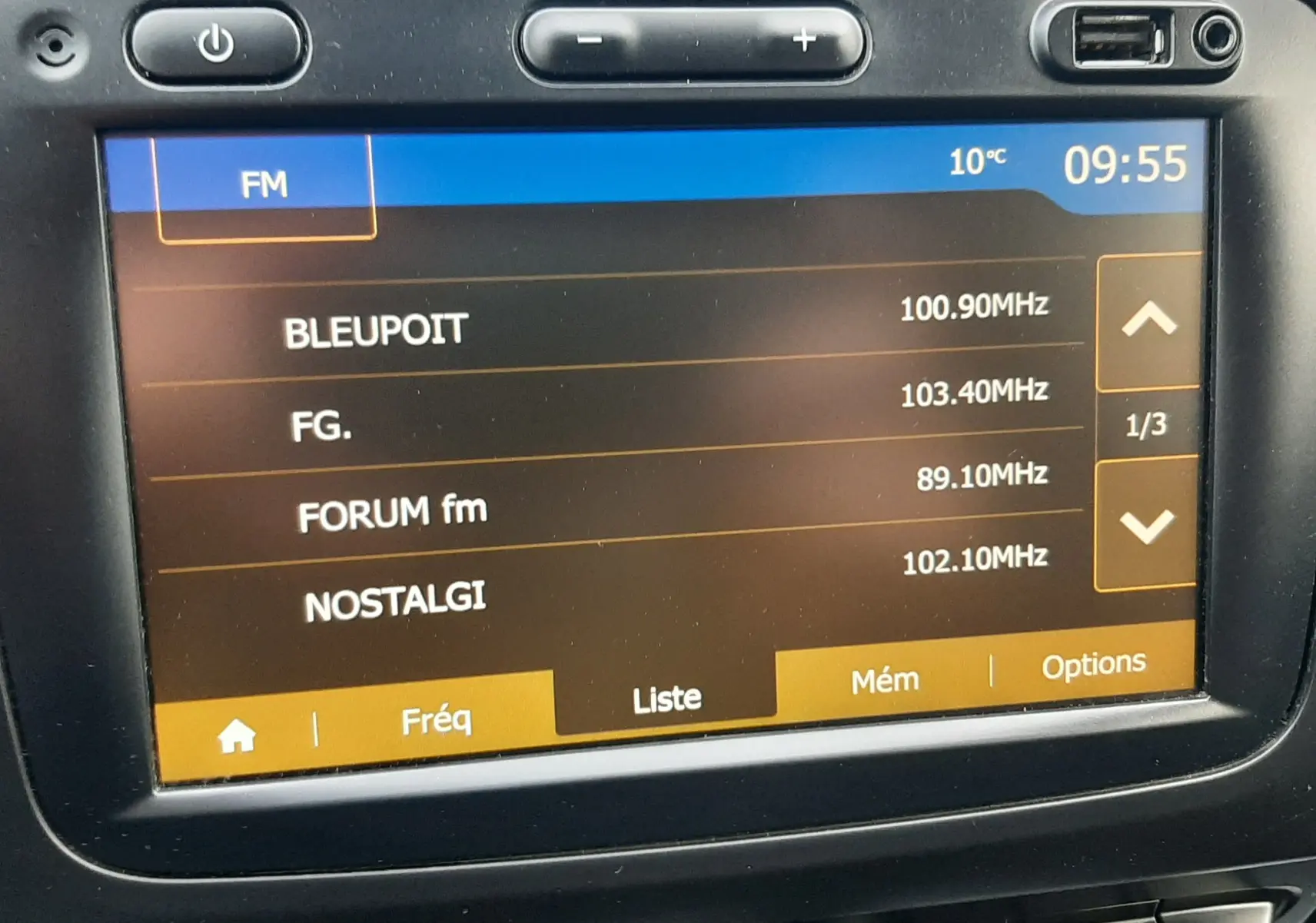 Écran tactile central du Dacia Duster 2019 affichant les stations FM, avec commandes et prises USB visibles en haut.