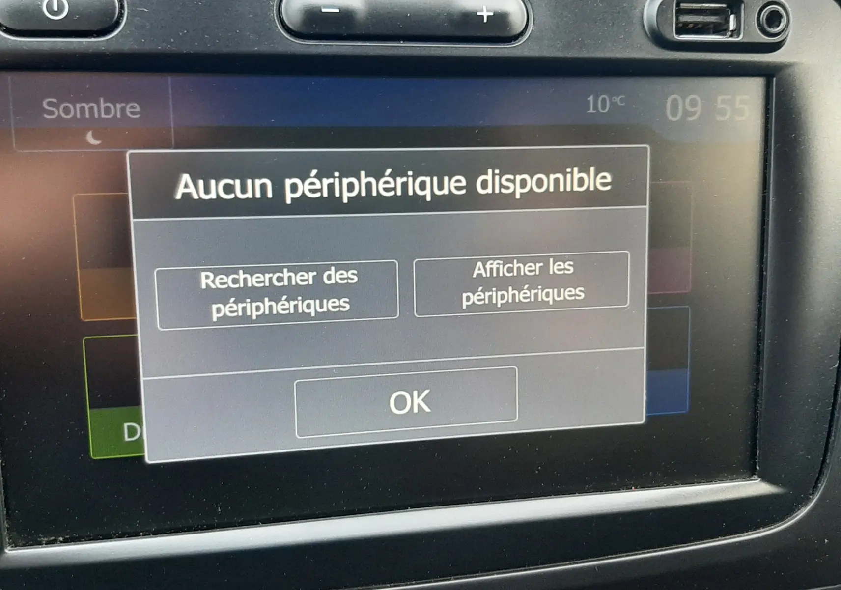 Écran tactile central du Dacia Duster 2019 affichant un message "Aucun périphérique disponible" avec boutons de contrôle autour.
