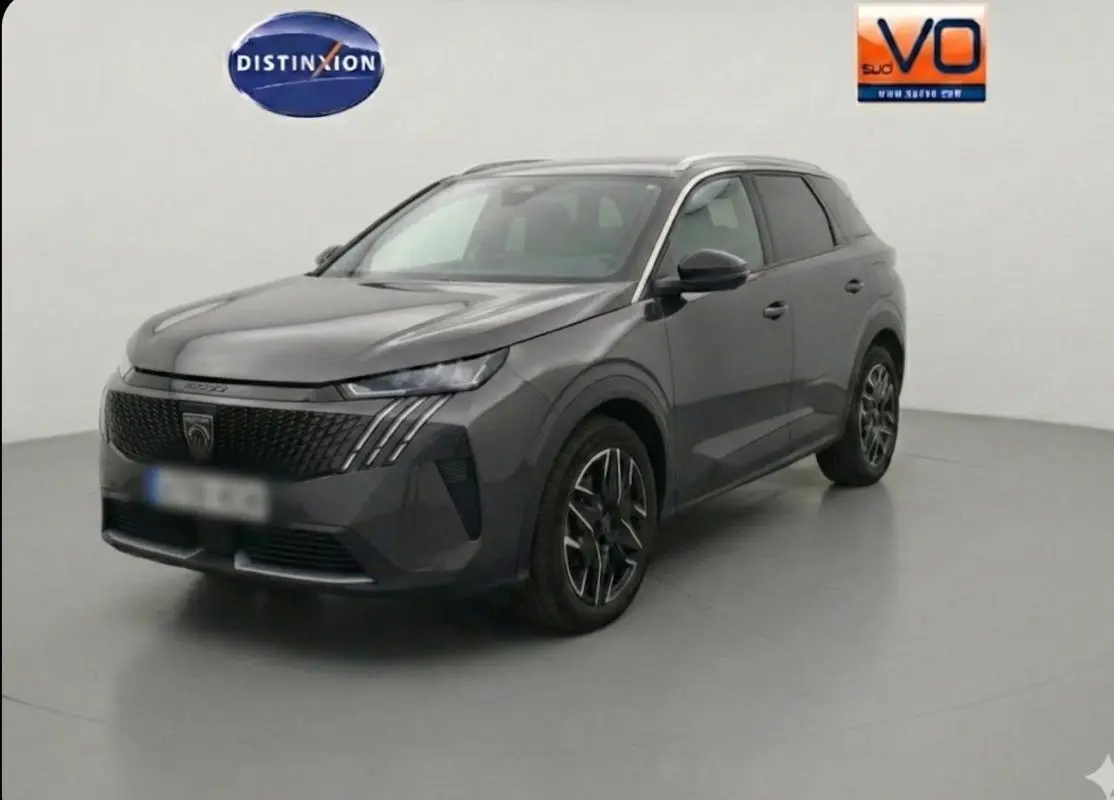 Peugeot 5008 Hybrid gris en 3/4 avant droit, avec jantes alliage 19 pouces et calandre noire distinctive.