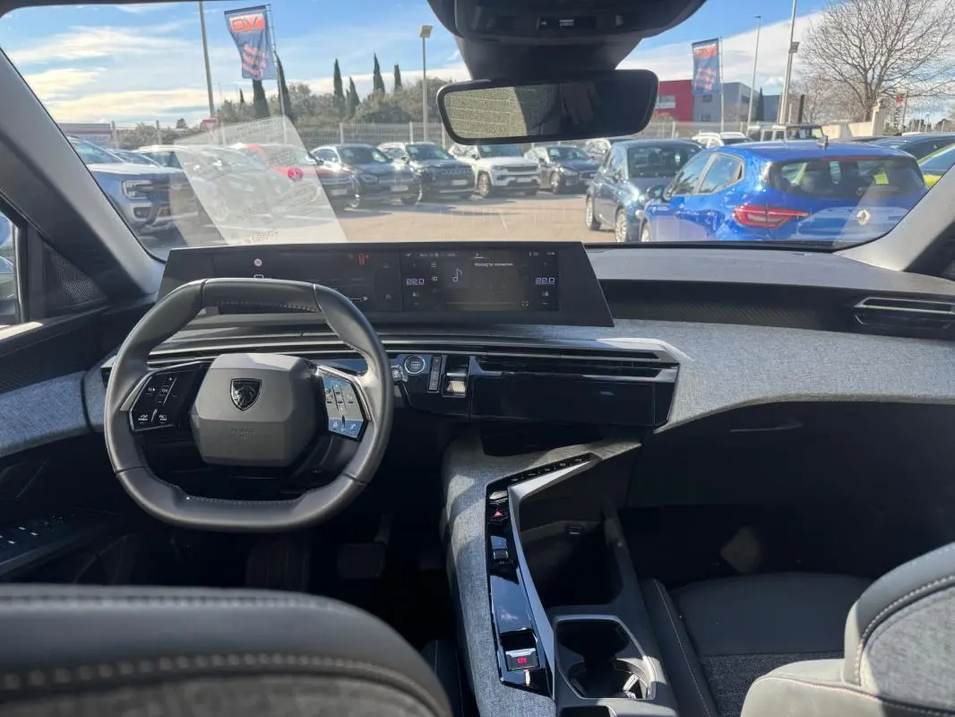 Vue intérieure du tableau de bord et volant noir du Peugeot 5008 Hybrid 145 e-DCS6 Allure 2025, avec cockpit numérique.