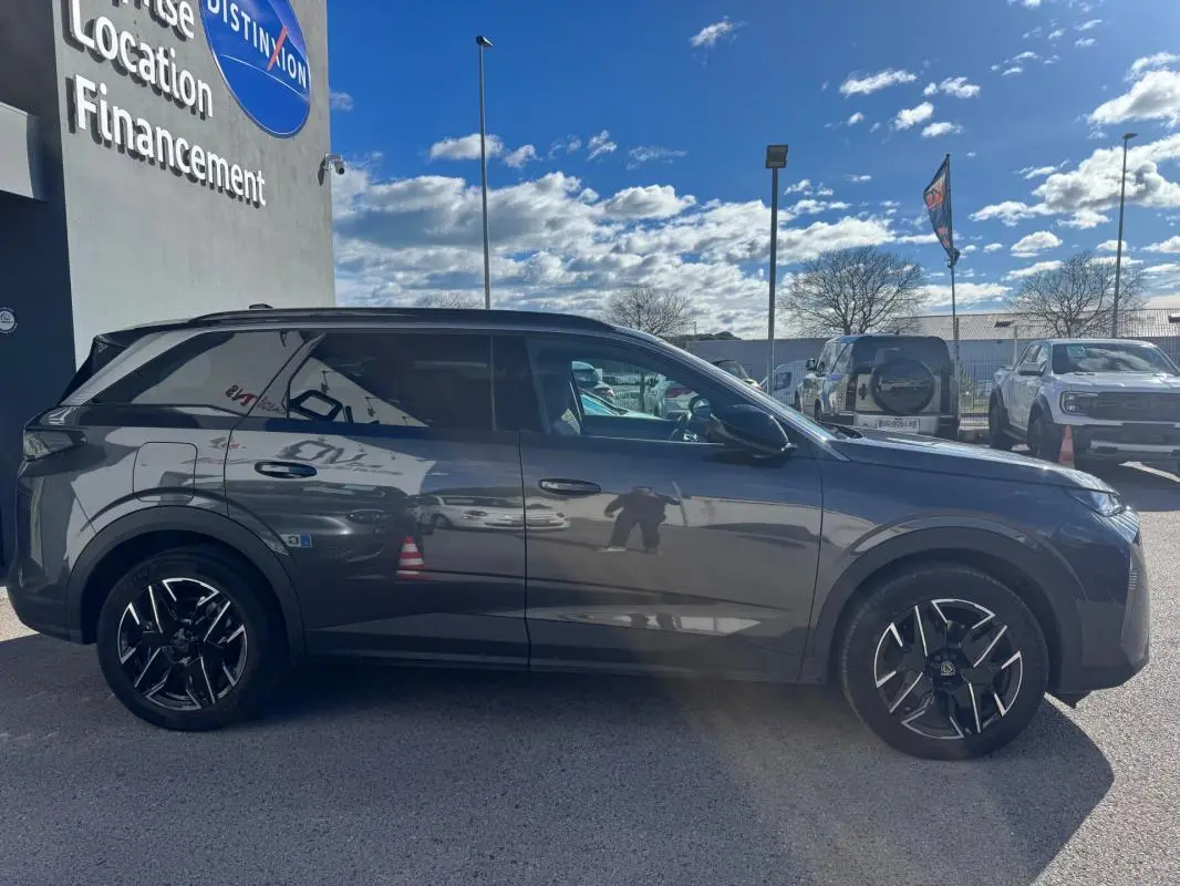 Peugeot 5008 gris vue de profil côté gauche, avec jantes alliage noires et vitres teintées.