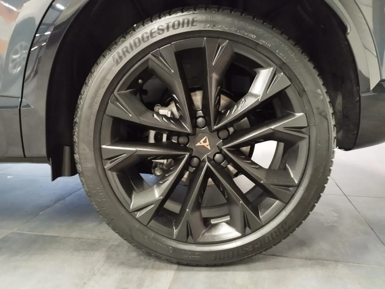 Vue rapprochée de la roue arrière droite d’un CUPRA Formentor 2026 en couleur Magnetic Tech, avec passage de roue noir.