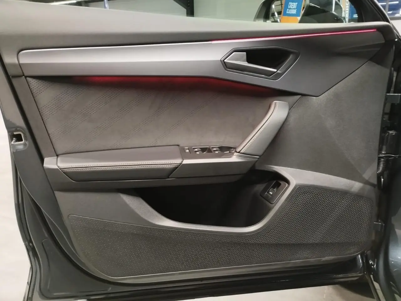 Contre-porte côté gauche de la CUPRA Formentor Magnetic Tech avec éclairage d’ambiance rouge et finition suédine noire.