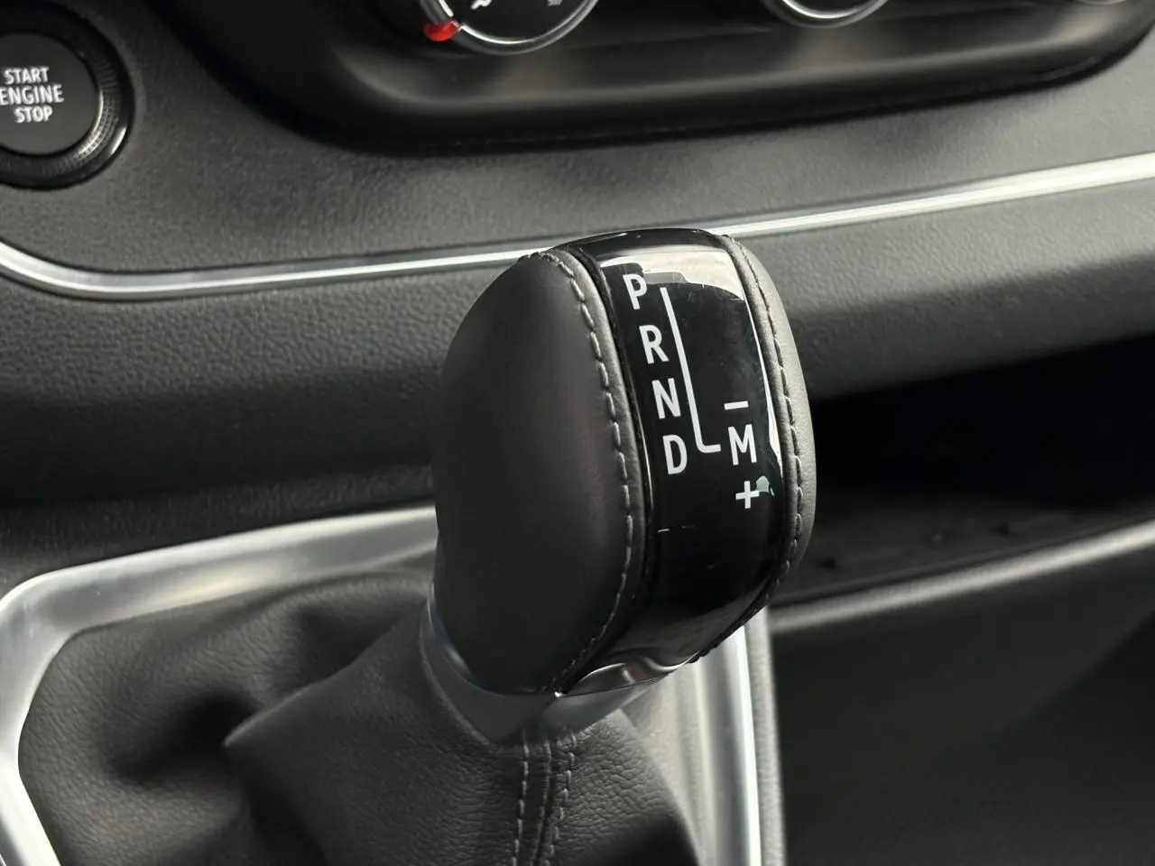 Gros plan sur le levier de vitesses automatique noir du Nissan Primastar 2025, avec marquages PRND et mode manuel.