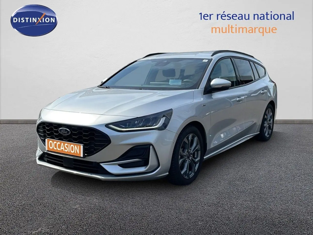 Ford Focus SW 1.0 EcoBoost MHEV 125ch ST-Line X gris lunaire, vue 3/4 avant droit sur sol bitumé.