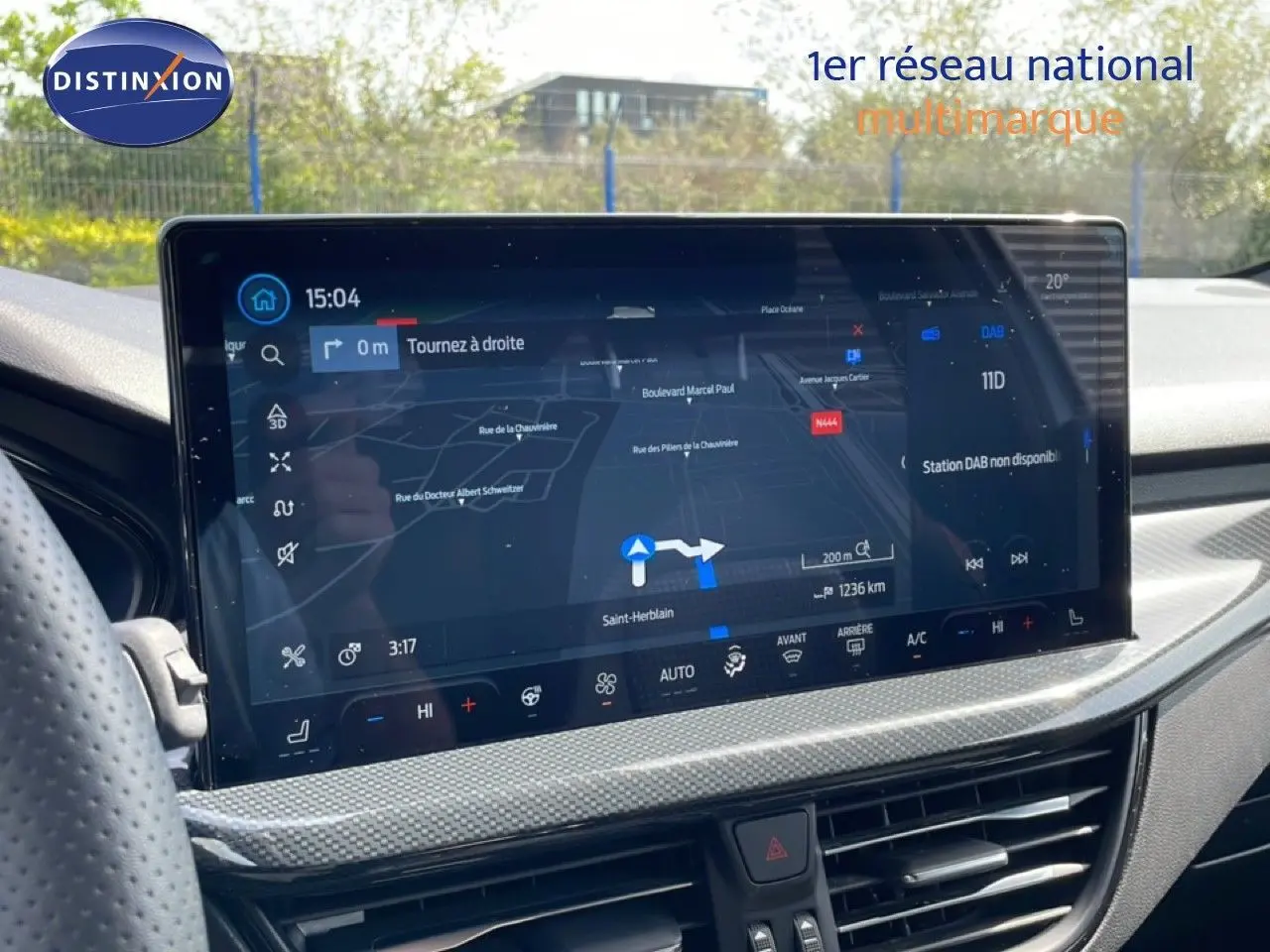 Vue intérieure du tableau de bord de la Ford Focus SW 2023, écran tactile affichant la navigation et la climatisation.
