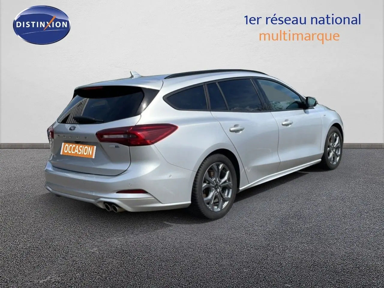 Vue 3/4 arrière droite d'une Ford Focus SW gris lunaire métal avec jantes alliage et double sortie d'échappement.