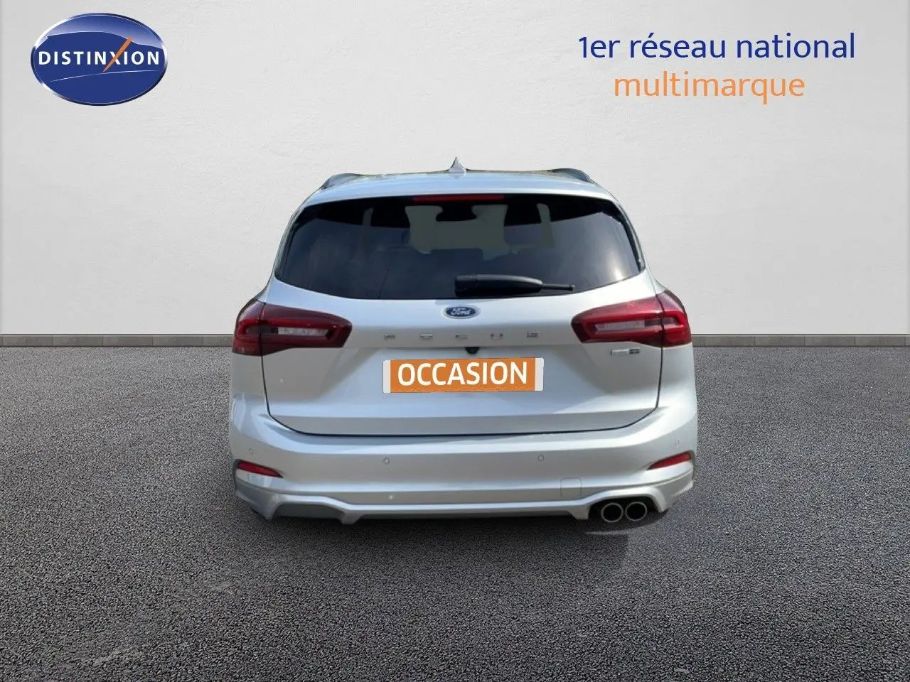 Vue arrière d'une Ford Focus SW gris lunaire métal 2023 avec double sortie d'échappement et vitres teintées.