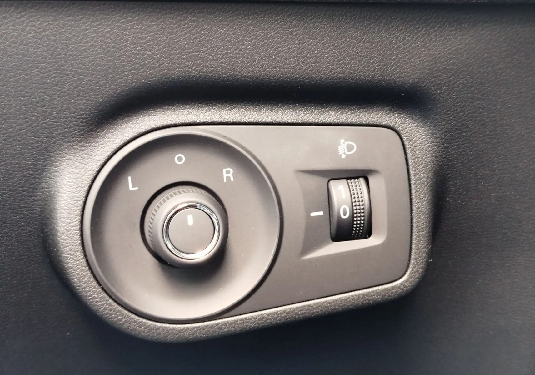 Gros plan sur la commande de réglage des rétroviseurs et de l'inclinaison des phares du MG ZS Cosmo Blue 2026.