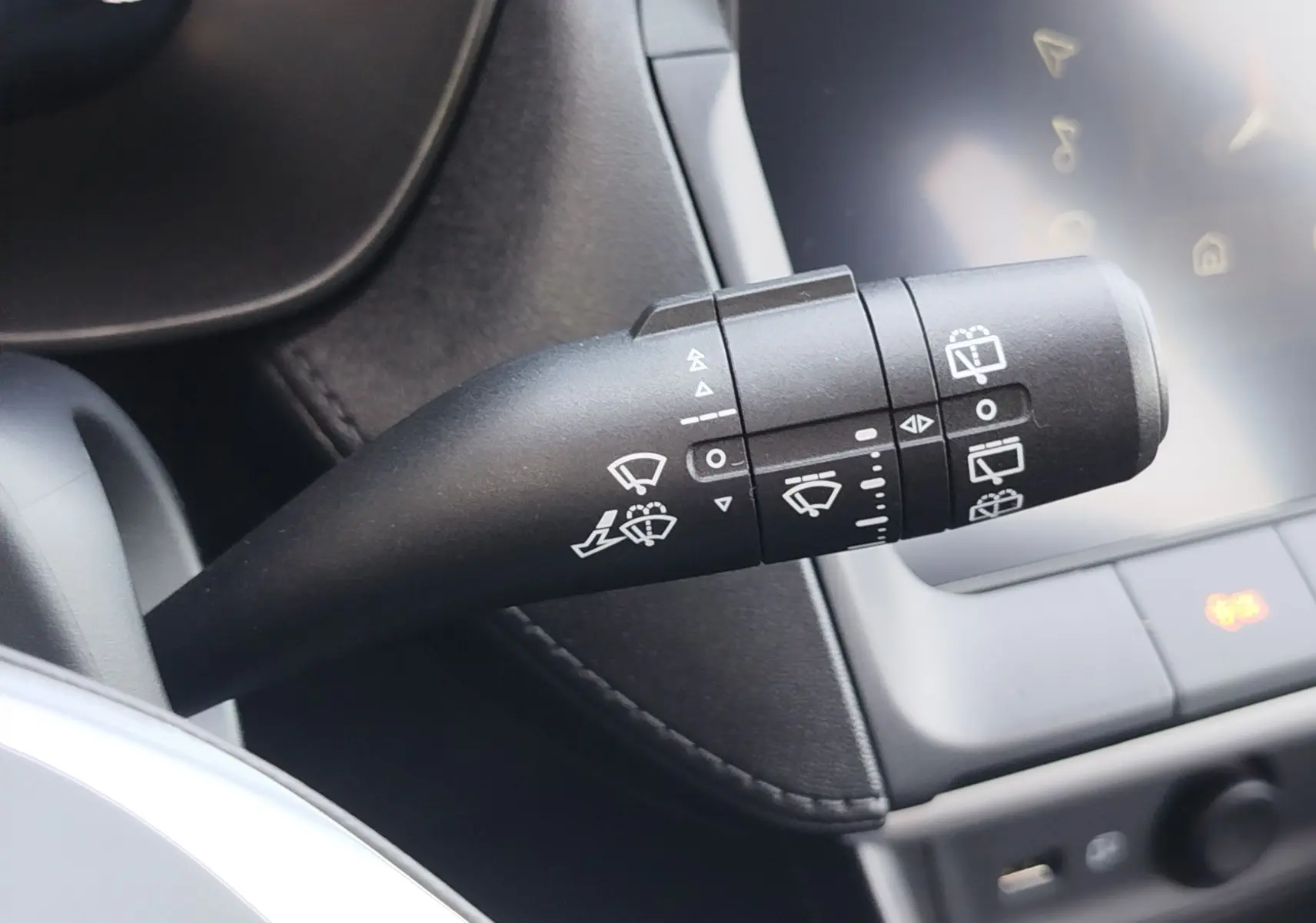Gros plan sur la commande des essuie-glaces du MG ZS 1.5 L Hybrid+ 2026, intérieur noir avec écran tactile visible.