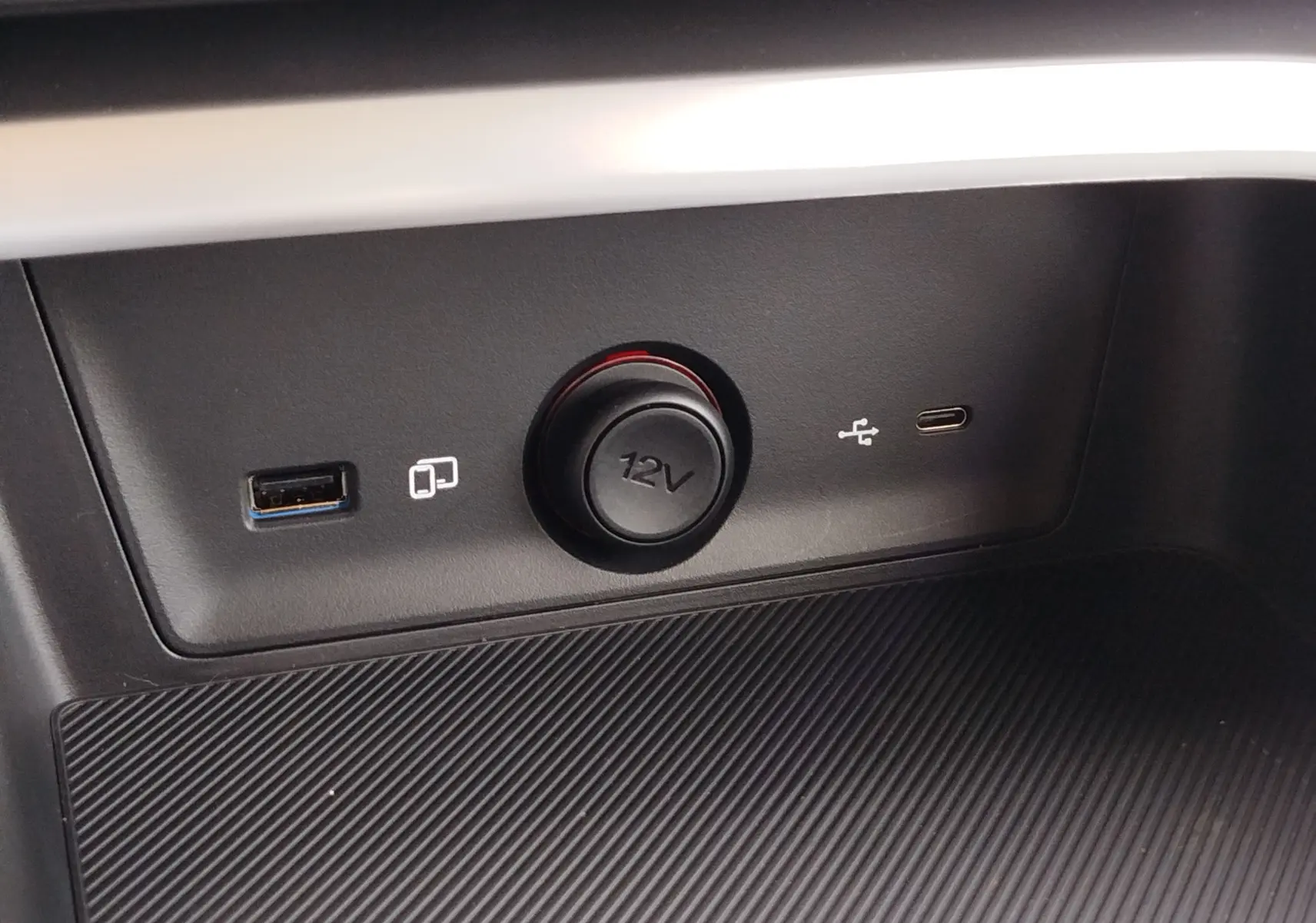 Gros plan sur la prise 12V et ports USB-A et USB-C intégrés dans la console centrale noire du MG ZS Cosmo Blue.