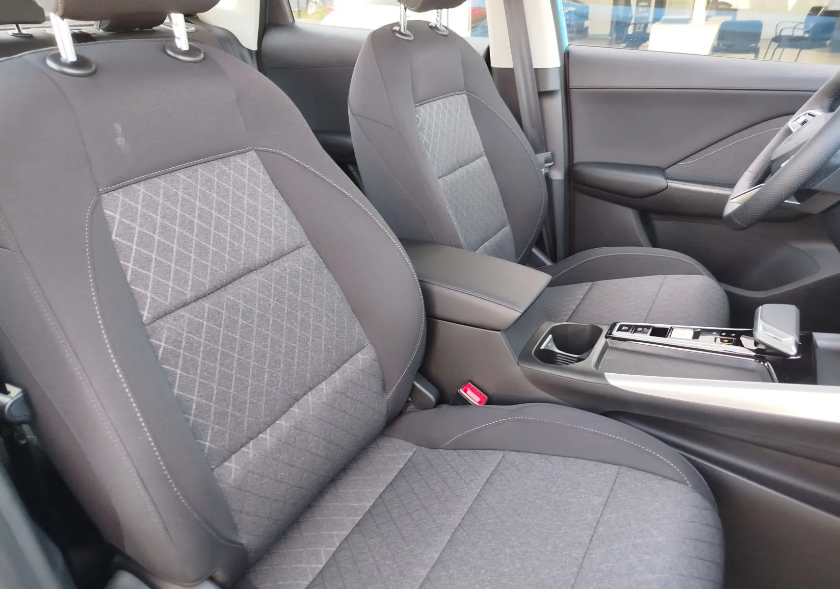 Vue intérieure côté avant droit montrant les sièges en tissu noir et la console centrale du MG ZS 2026.