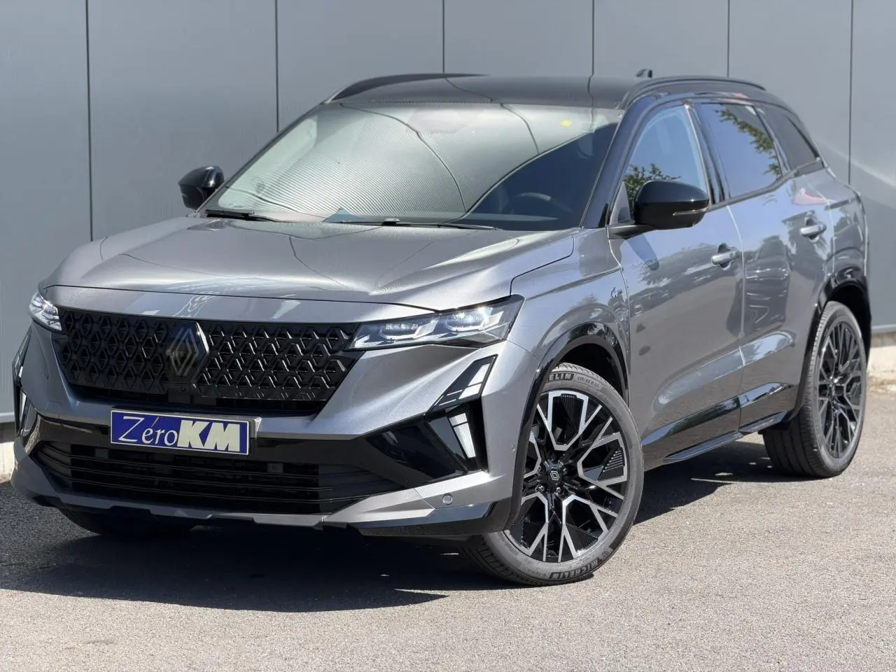 Renault Austral E-Tech gris schiste avec toit noir, vue 3/4 avant mettant en valeur la calandre et jantes noires.