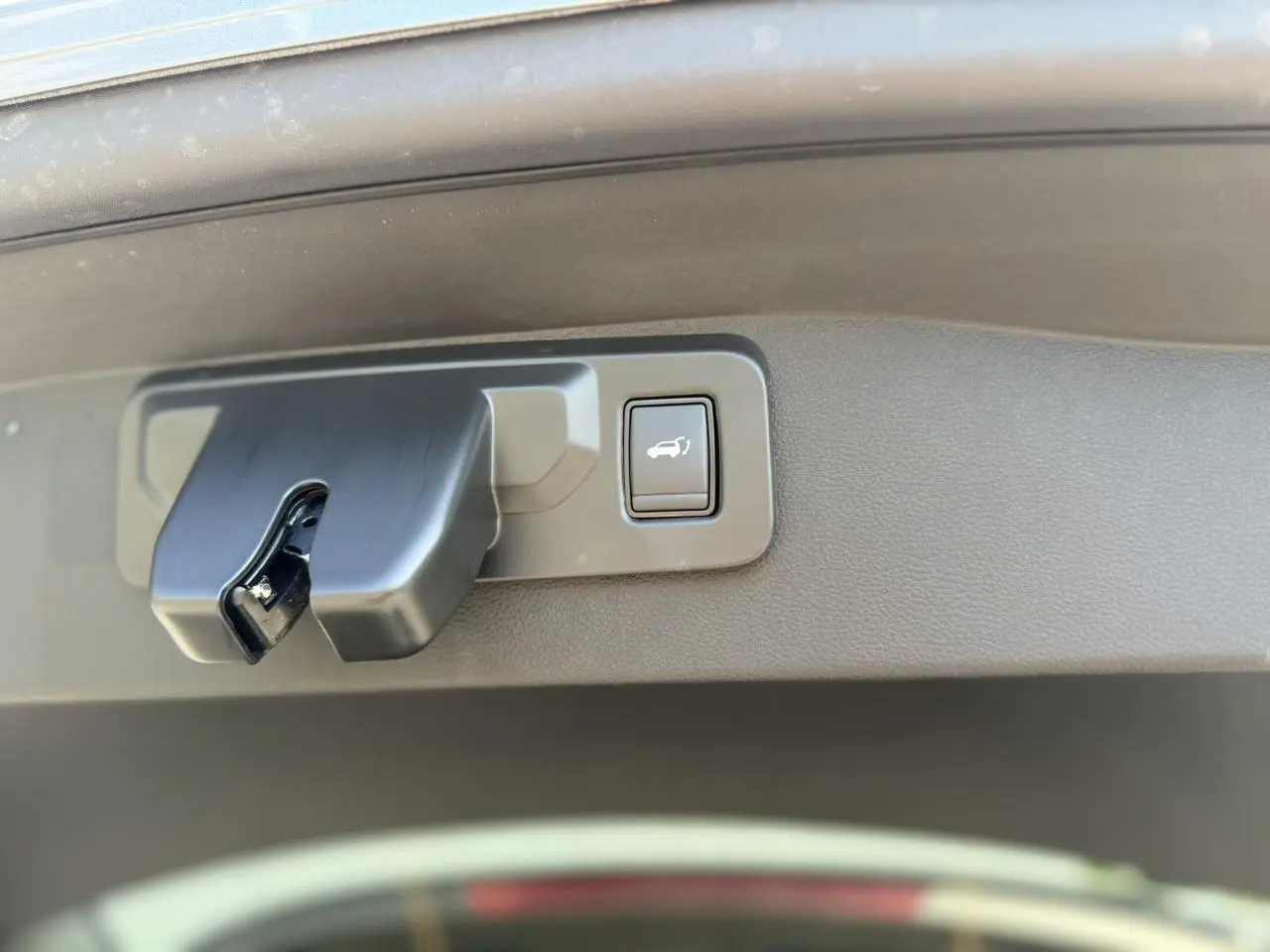 Gros plan sur le mécanisme d'ouverture du hayon électrique du Renault Austral E-Tech gris Schiste.