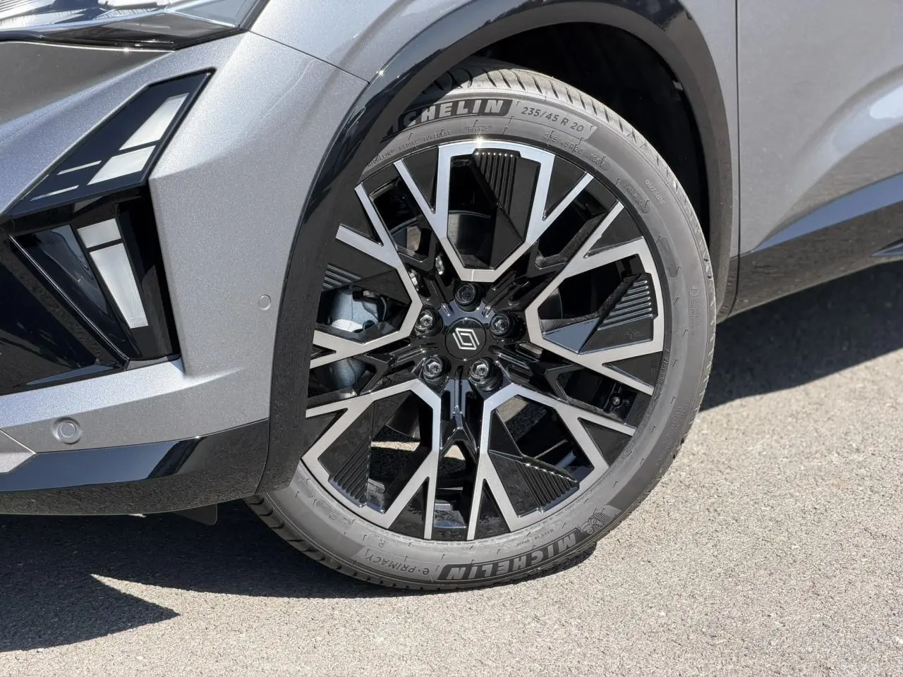Gros plan sur la roue avant droite du Renault Austral gris Schiste avec jante alliage noire et argentée diamantée.