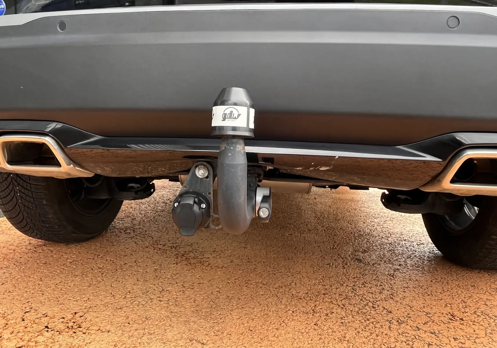 Gros plan sur l'attelage arrière du Peugeot 2008 noir 2024, mettant en valeur la prise électrique et le pare-chocs.