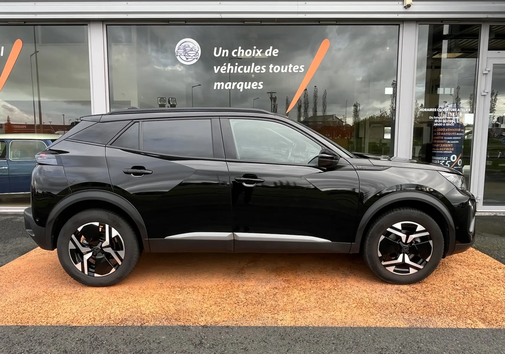 Peugeot 2008 noir vue de profil côté gauche, avec jantes alliage noires et détails modernes sur carrosserie.