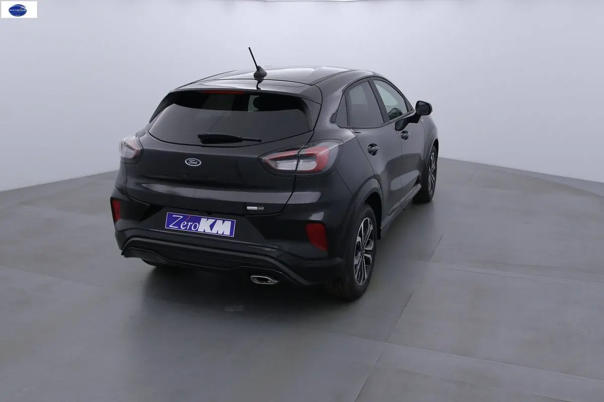 Vue 3/4 arrière droite d'une Ford Puma noire Agate Metal avec feux arrière LED et jantes alliage bicolores.