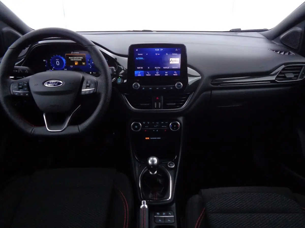 Intérieur noir du Ford Puma 2022, vue de face sur le tableau de bord, volant multifonction et écran tactile central.